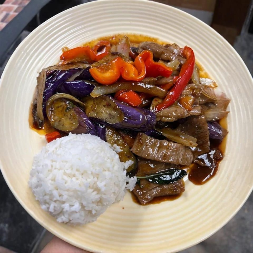 Thai Orchid's stir-fried beef with purple eggplant, red bell peppers, onions, and white rice.